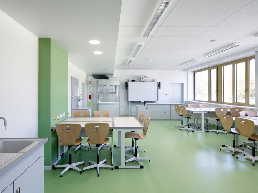 The colors light blue, turquoise, green and yellow green are present, used in the rubber flooring in the classrooms and administrative spaces.