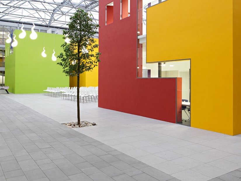 Planted trees and the color design soften the atmosphere in the school courtyard.