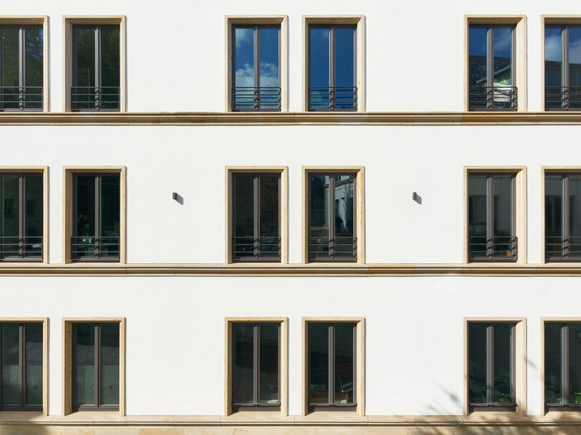 The yellowish color shade corresponds to the polished facade, in off-white and anthracite-colored wooden windows.