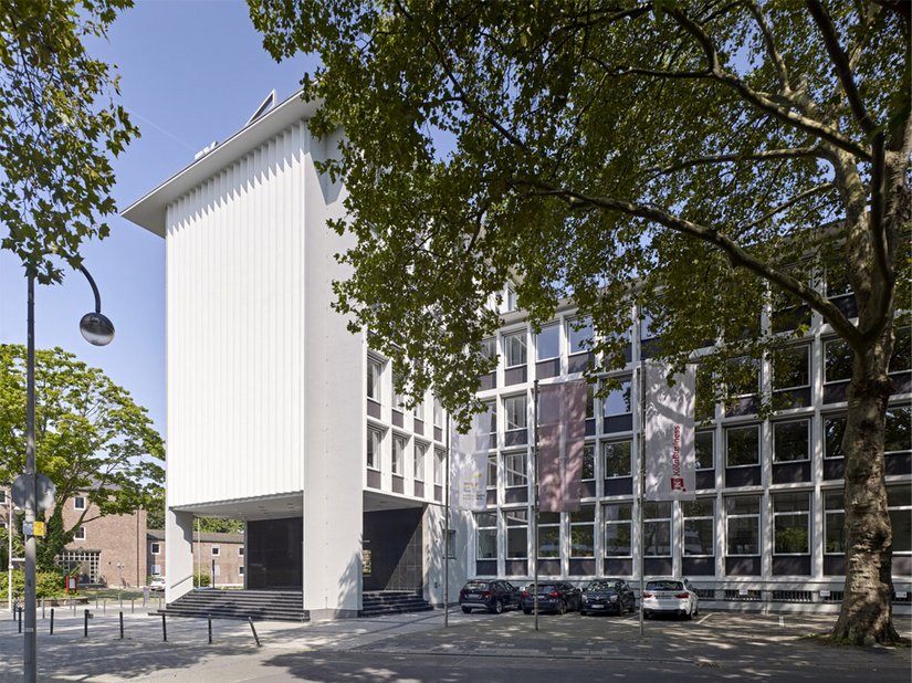 The exposed concrete facade appears in white and is flanked by the adjacent concrete supports, which were coated in a warm gray shade.