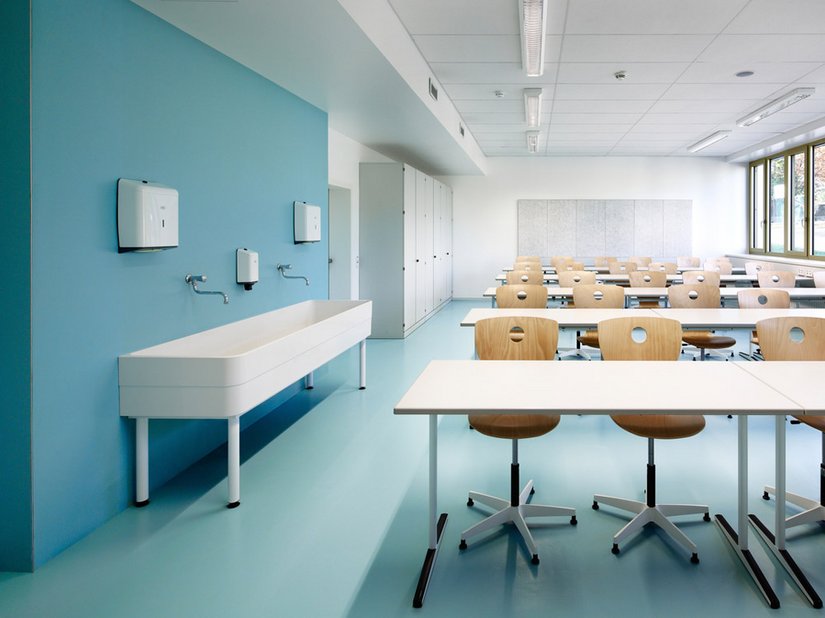 The colors light blue, turquoise, green and yellow green are present, used in the rubber flooring in the classrooms and administrative spaces.