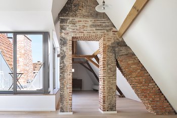 <p>A brick chimney, the wooden beams, and the roof timbering are reminiscent of the past. The old wooden windows were reconstructed. All new windows installed, along with the staircases and balconies, are made of steel.</p>