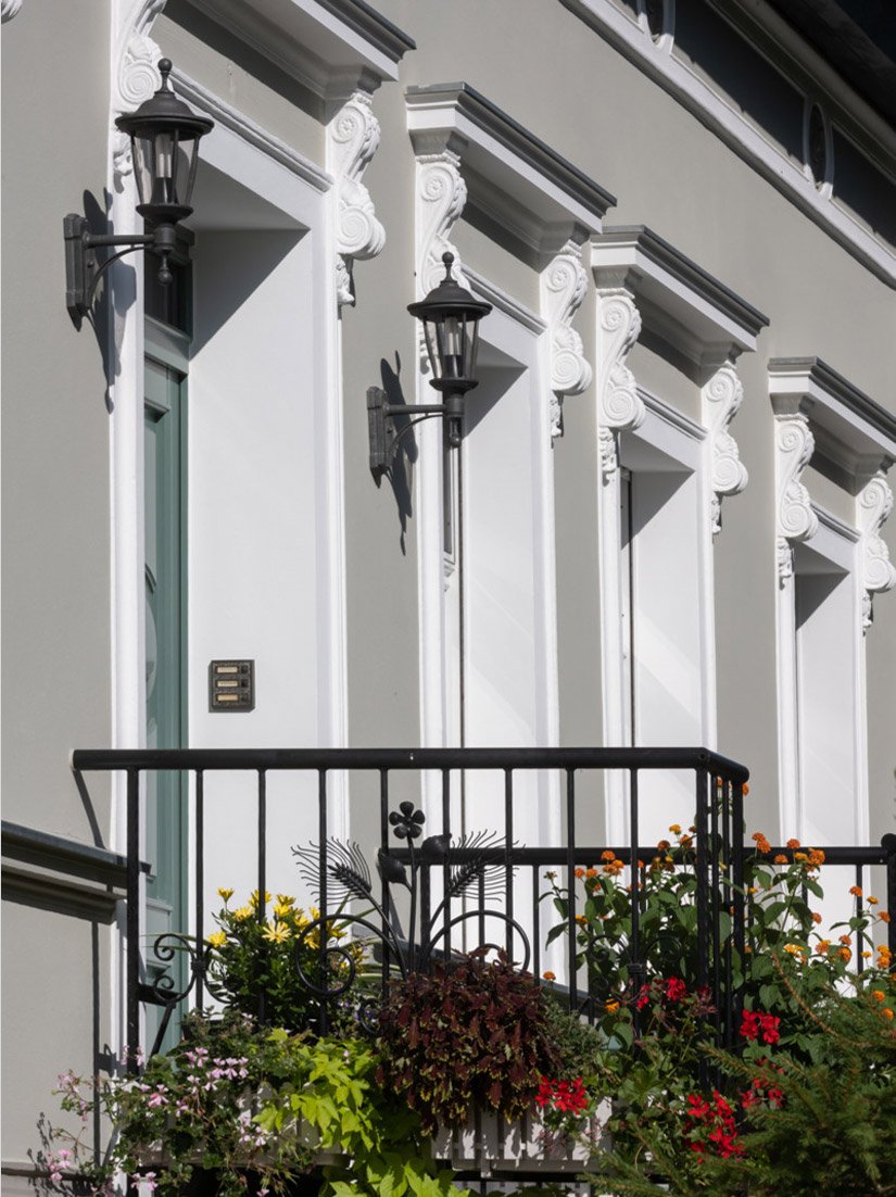 The split windows, the newly added and framing pilaster strips and cornice bands give the small house an almost noble appearance to make it stand out.