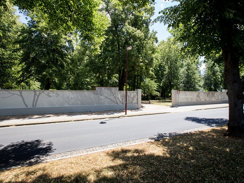 When walking along the sidewalk, the observer can see the interplay of abstract lines in light and dark gray tones.