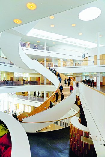 <p>The meeting place: The wooden spiral staircase forms the center of the school. With its open design, the school has neither separate classrooms or teachers' rooms.</p>