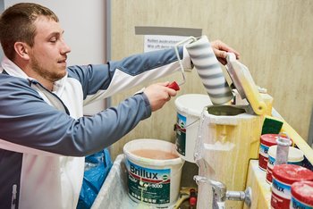 <p>Cleaning utensils is also part of the job: Painter and decorator trainee Patrick Weigand cleaning the paint rollers</p>