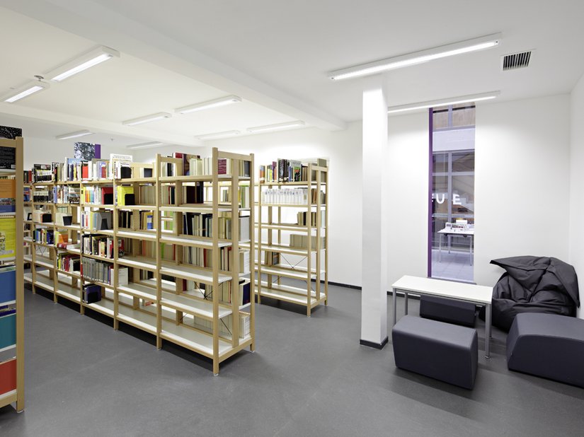 In the media library, cozy beanbags and upholstered stools invite people to read.