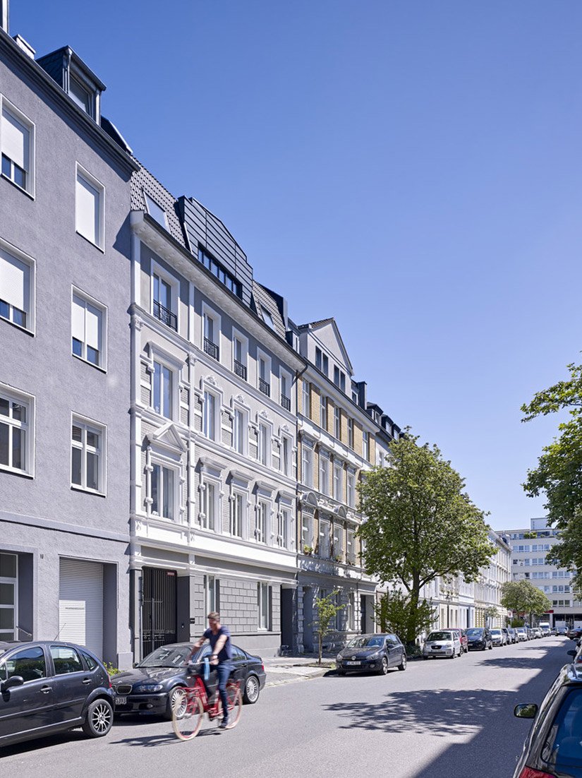 The ground floor has been painted in a darker gray shade than the rest of the facade, giving the building solidity and visual appeal.