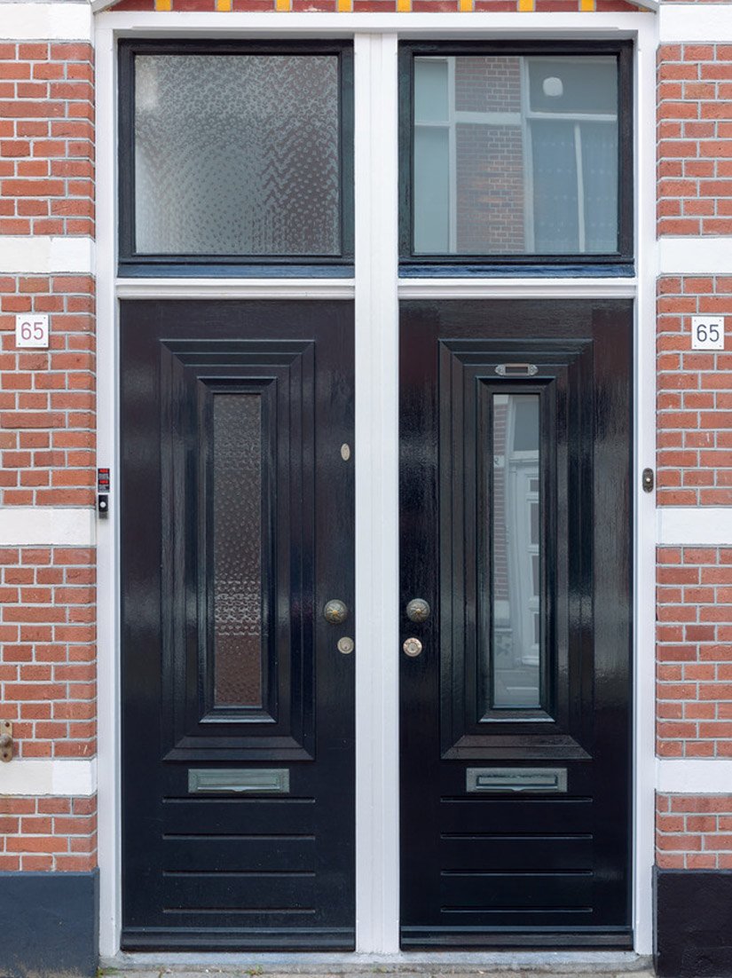 Gleaming black door and window elements interrupt the facade image.