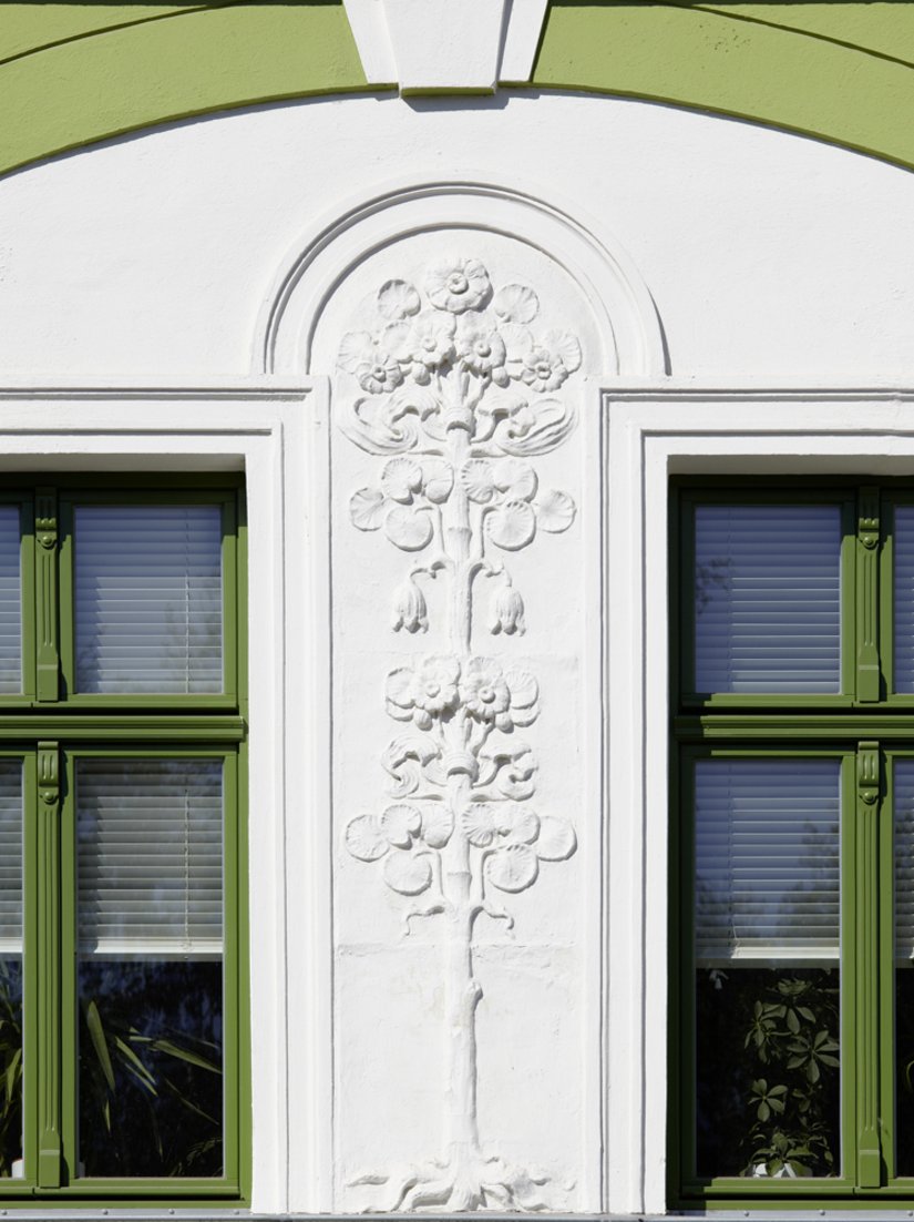 The window frames painted in bold green are a particular design highlight.