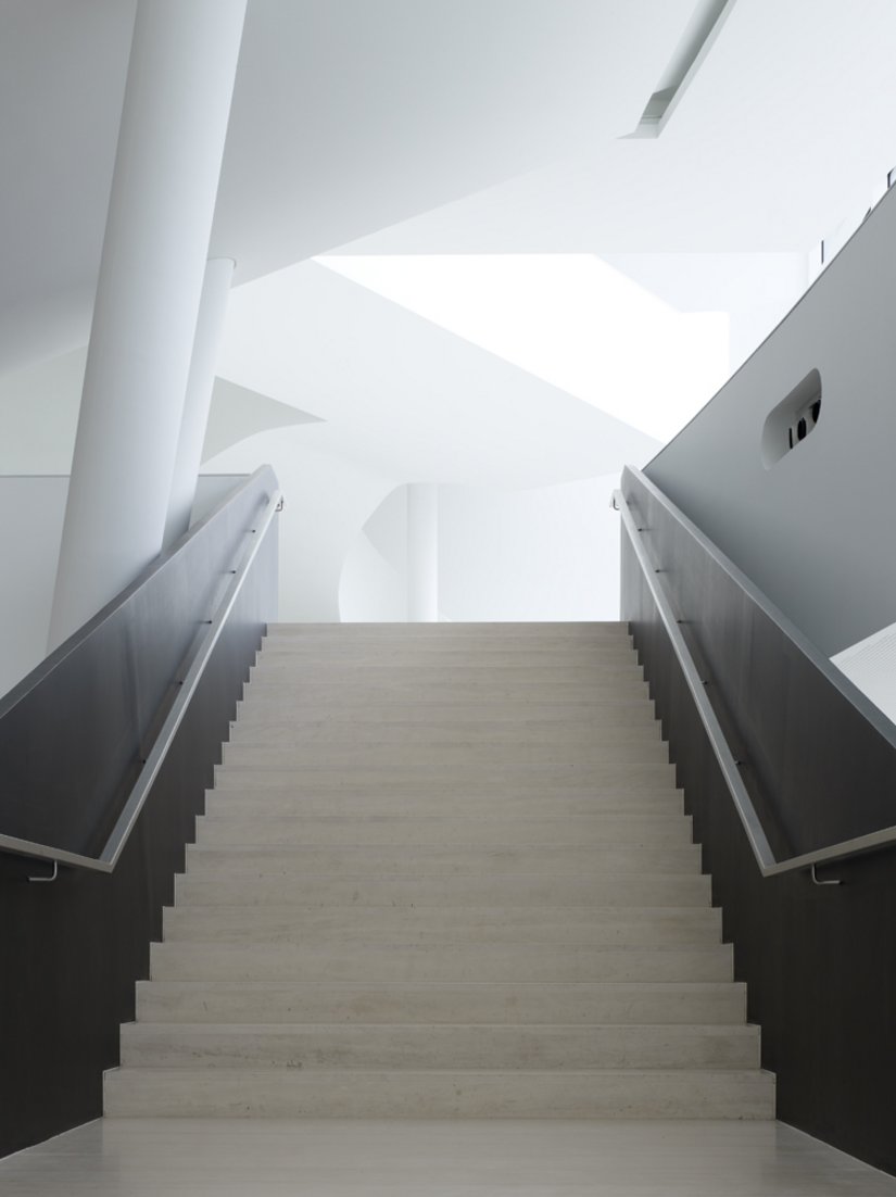 The banister is a dark accent in the sea of pure white.