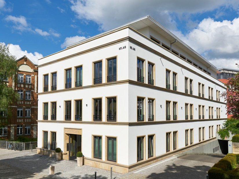<p>The building features a facade punctuated by windows, divided with a uniform, classical rhythm.</p>