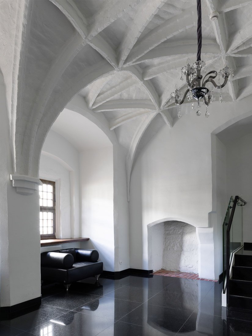 The vaulted ceiling contrasts with the glossy floor and modern furnishings.