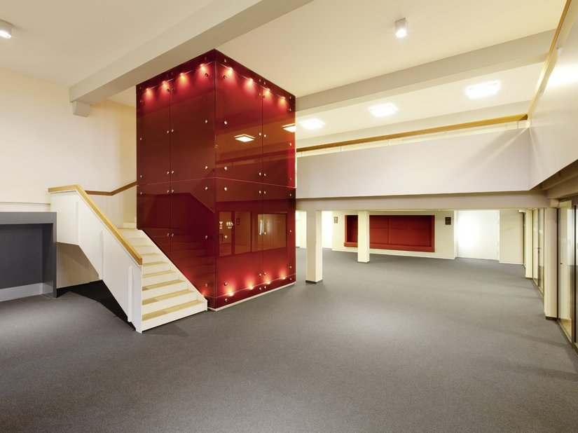 New steel stairs and an elevator with red paneling lead to the seminar rooms on the first and second floor.