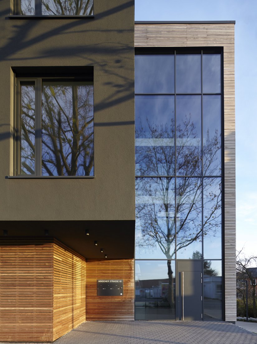 The filigree texture of the horizontal wooden slats removes some of the harshness from the reinforced concrete structure and creates an effective contrast with the dark, monochrome rendered facade.