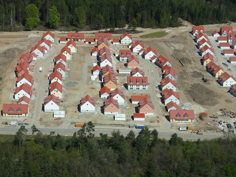 The vibrant color shade variety of the facades is visible on the aerial view of the completed building stages to the east.