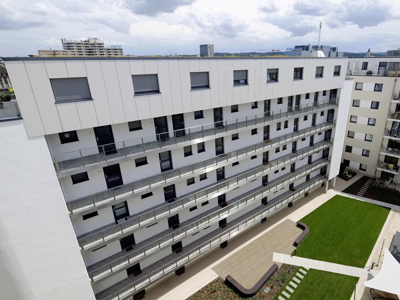 The penthouse level with maisonette apartments is emphasized by the ultra-modern metal facade in white metallic.