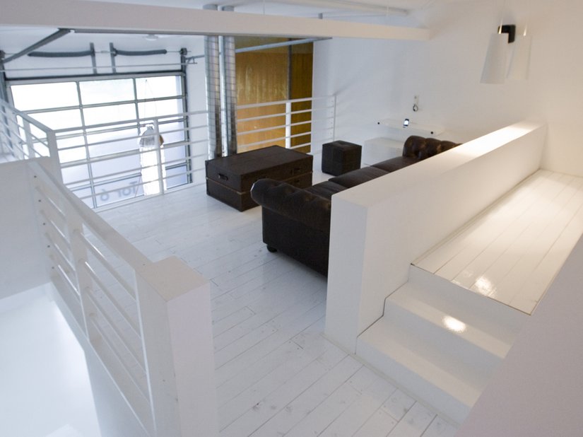 On the gallery: a minimalistic living space that highlights the raw, elegant appearance of the painted wooden floor boards particularly effectively.